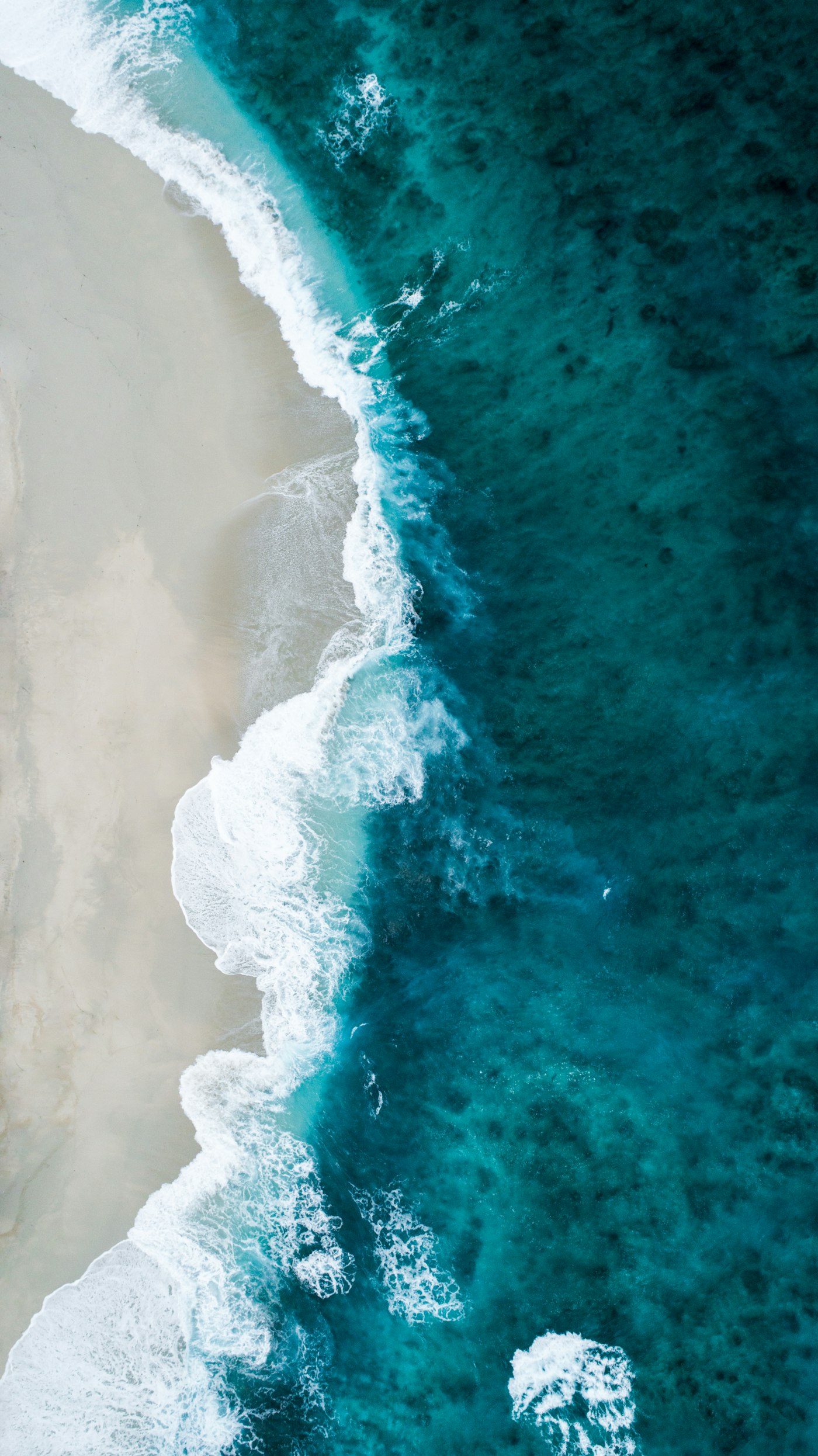 Aerial placeholder photograph of a shoreline where shallow water meets deep water.